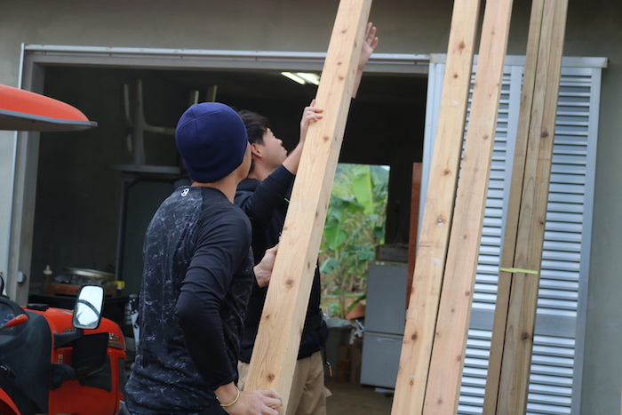 木材を立て掛ける男性